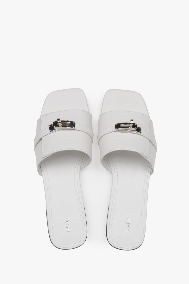 Classic white Estro women's slide sandals, refreshingly accented with a silver embellishment — perfect for summer and comfortable thanks to the flat sole.