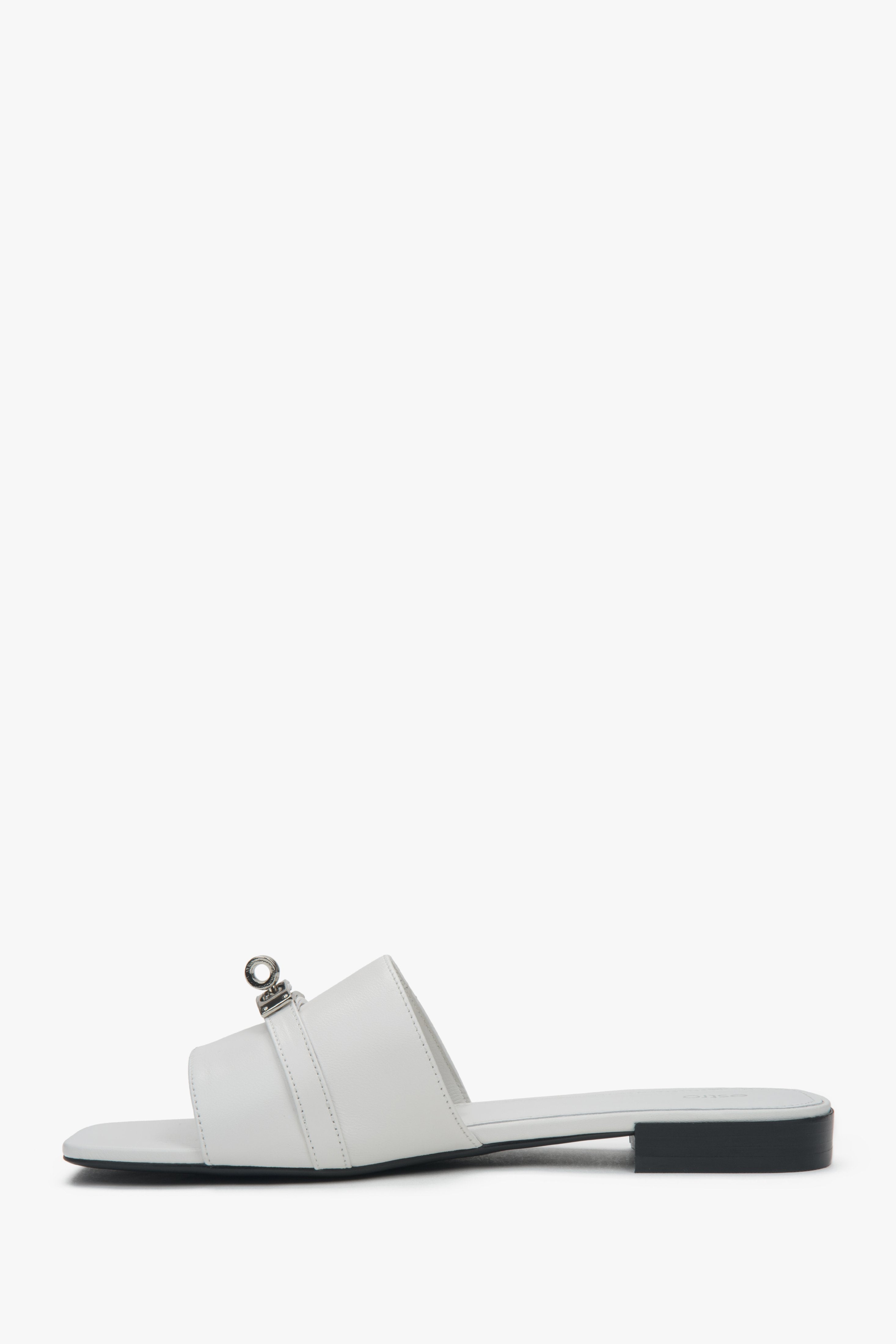 Stylish white Estro women's slide sandals, featuring a subtle silver embellishment and offering comfort thanks to the flat heel.