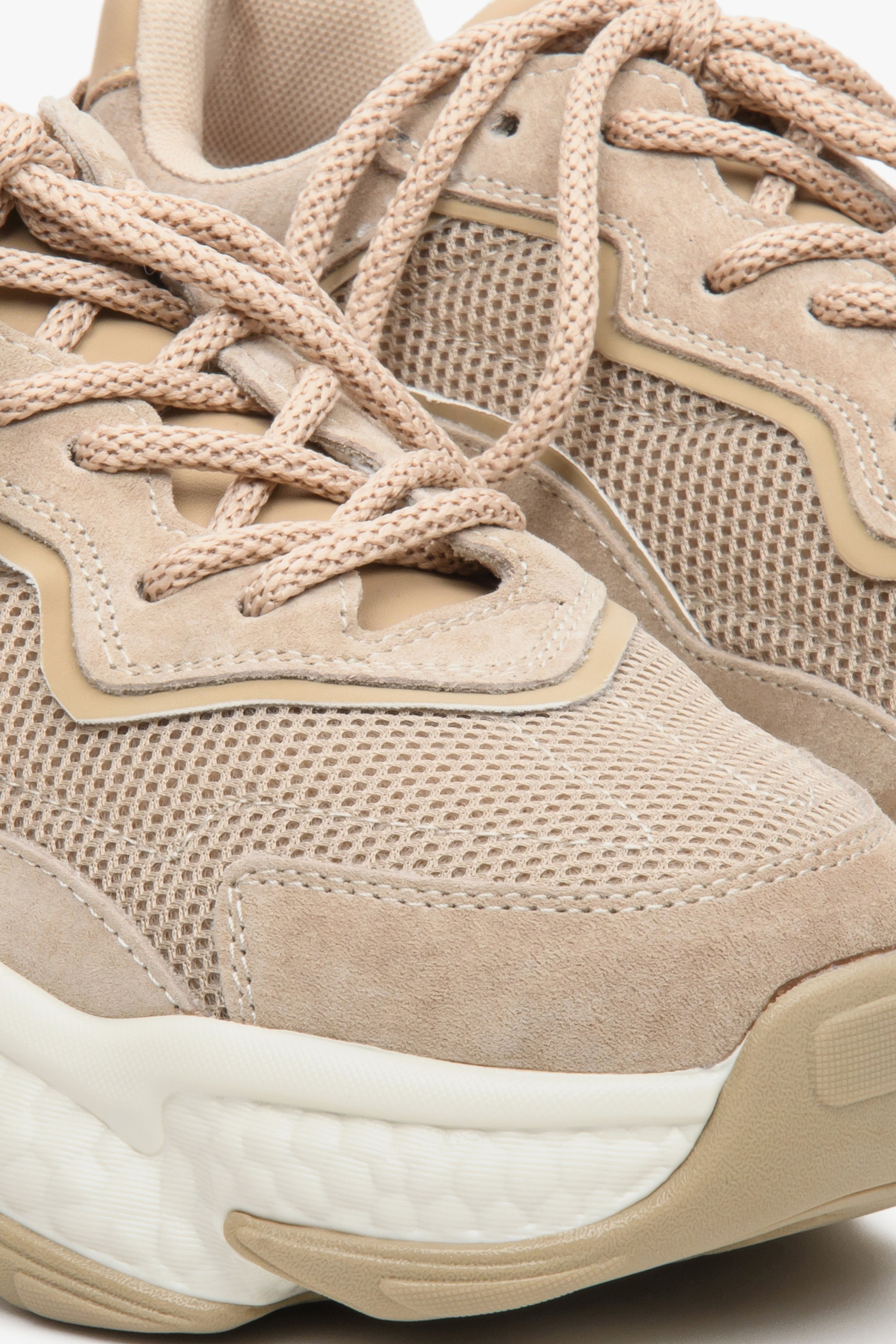 Beige women's sneakers with suede and textile on a chunky sole - close-up on the details.