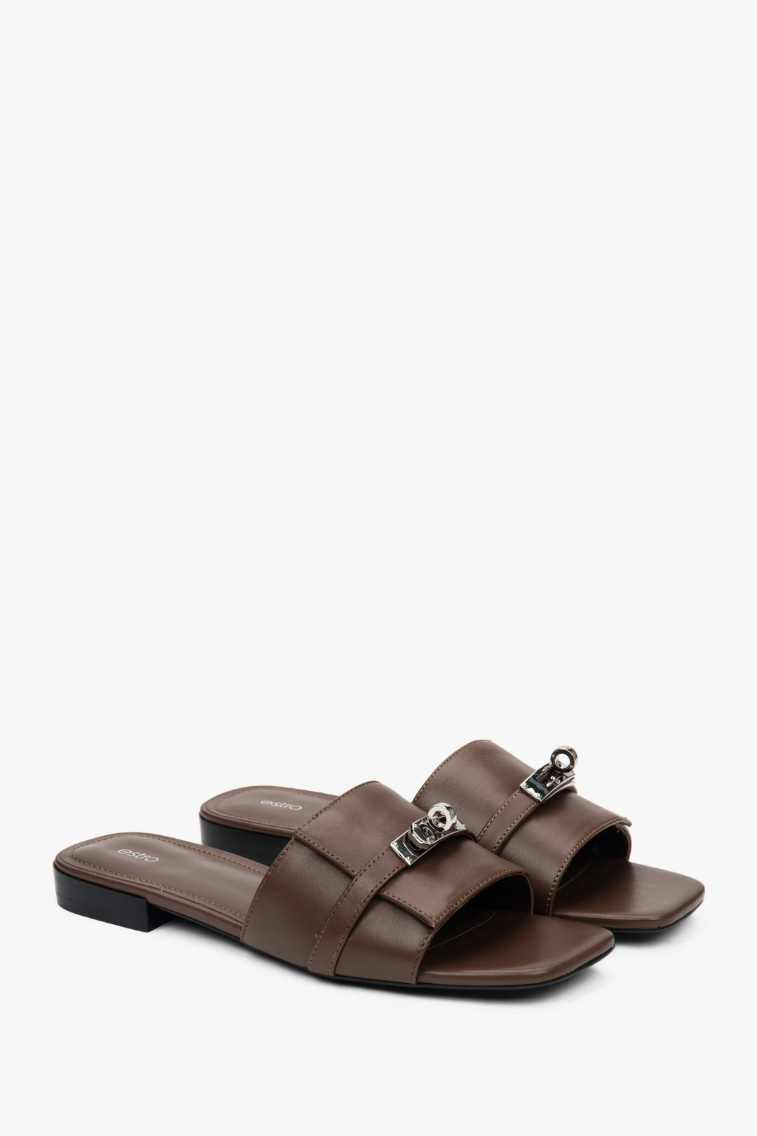 Elegant dark brown Estro women's slide sandals, adorned with a silver embellishment, perfect for everyday wear, featuring a comfortable flat heel.
