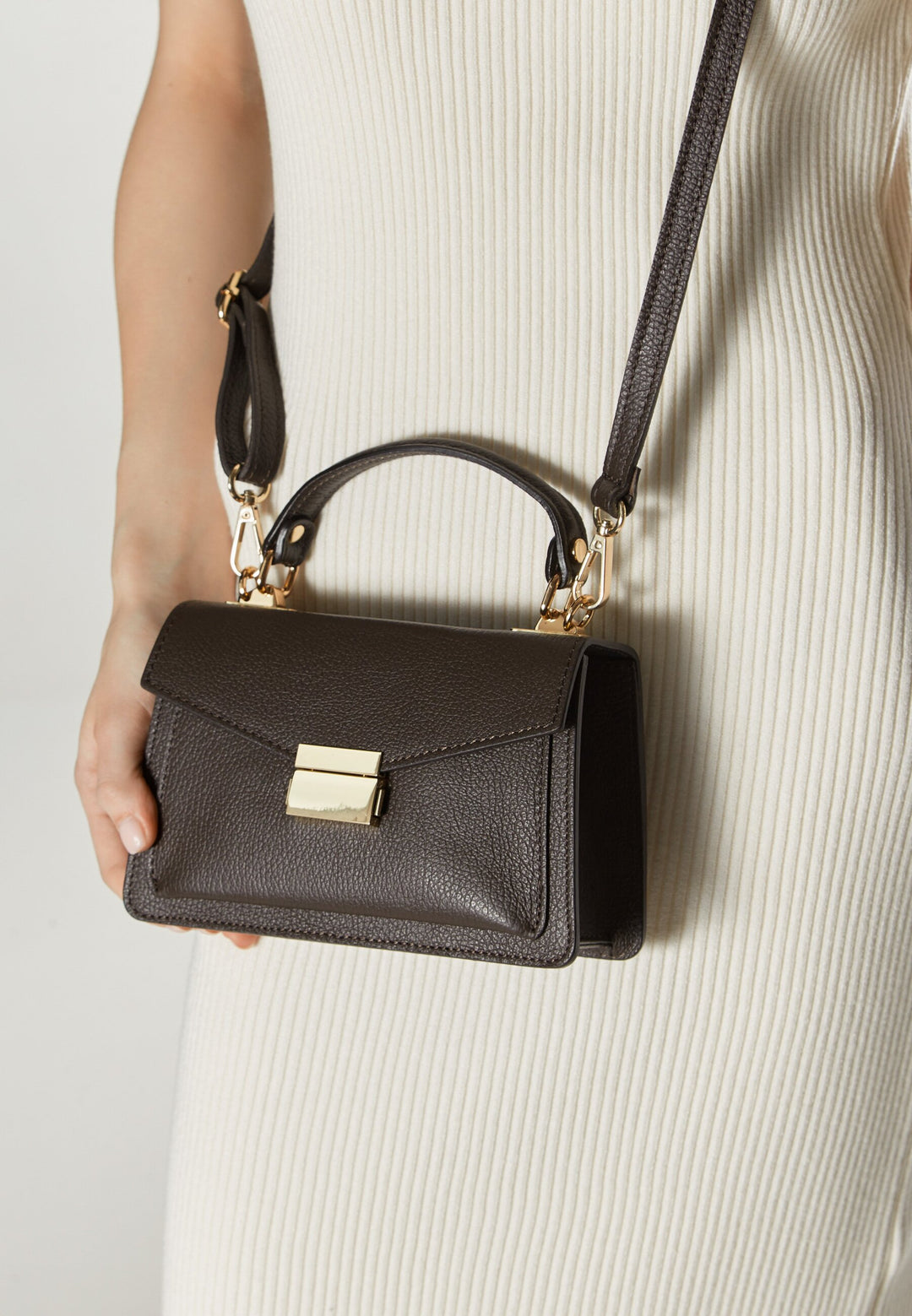 Women's small dark brown handbag made of premium Italian genuine leather by Estro  – presented on a model.