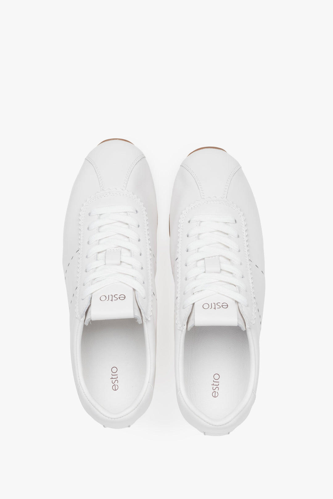 White women's sneakers made of natural leather with a thin sole by Estro – top view presentation.