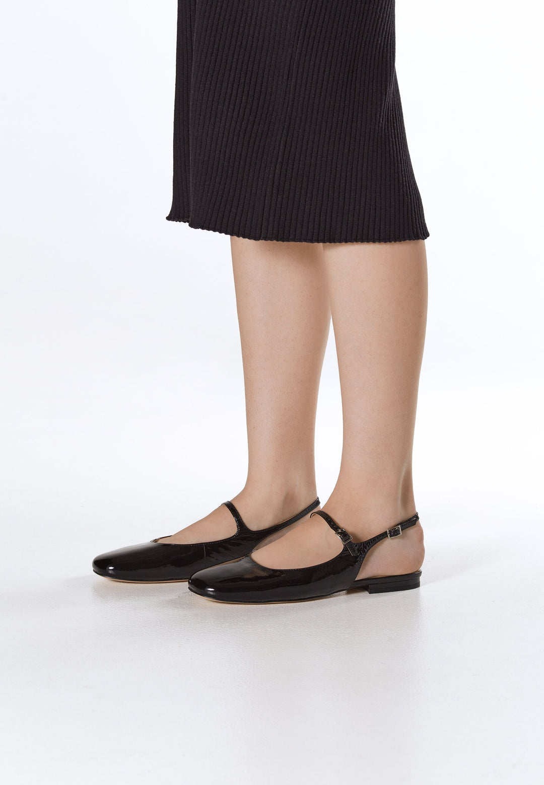 Elegant black patent leather slingback flats from Estro – on-foot presentation.