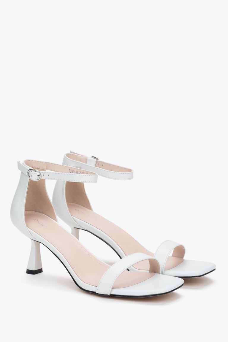 Chic white sandals by Estro, made with high-quality leather, featuring a unique funnel heel that provides both style and support.