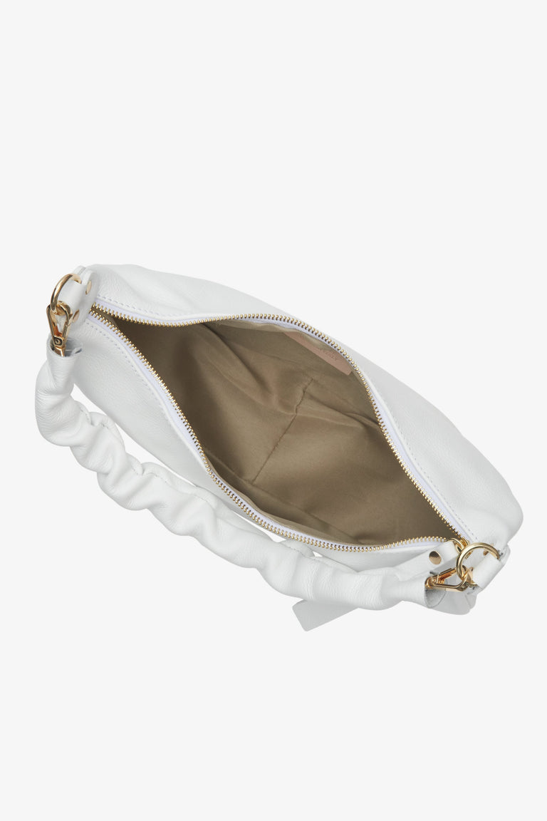 Stylish white half-moon shpulder bag fastened with a zip - close-up on the lining.