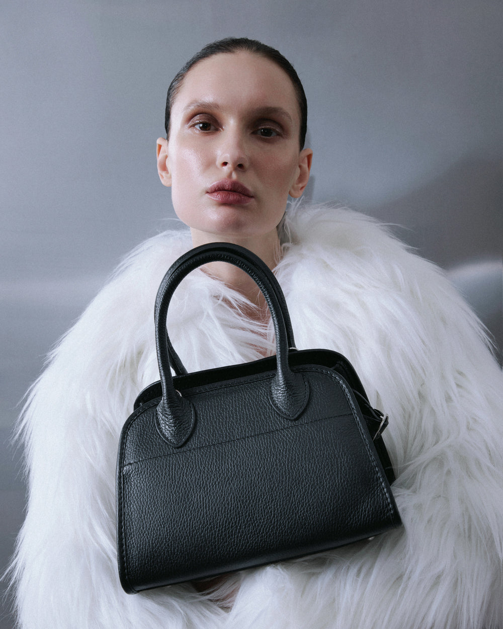 A women's handbag - a black satchel by Estro.