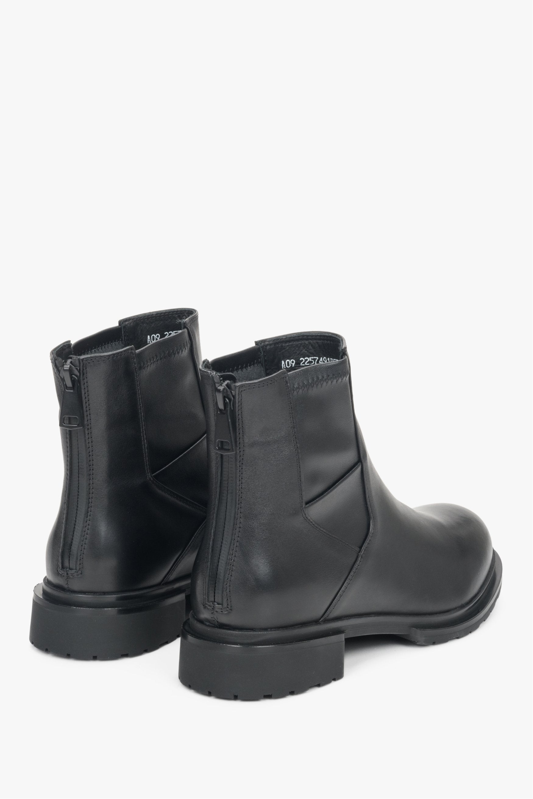 Women's black boots made of genuine leather - close-up on the side line and heel counters with a silver zipper .