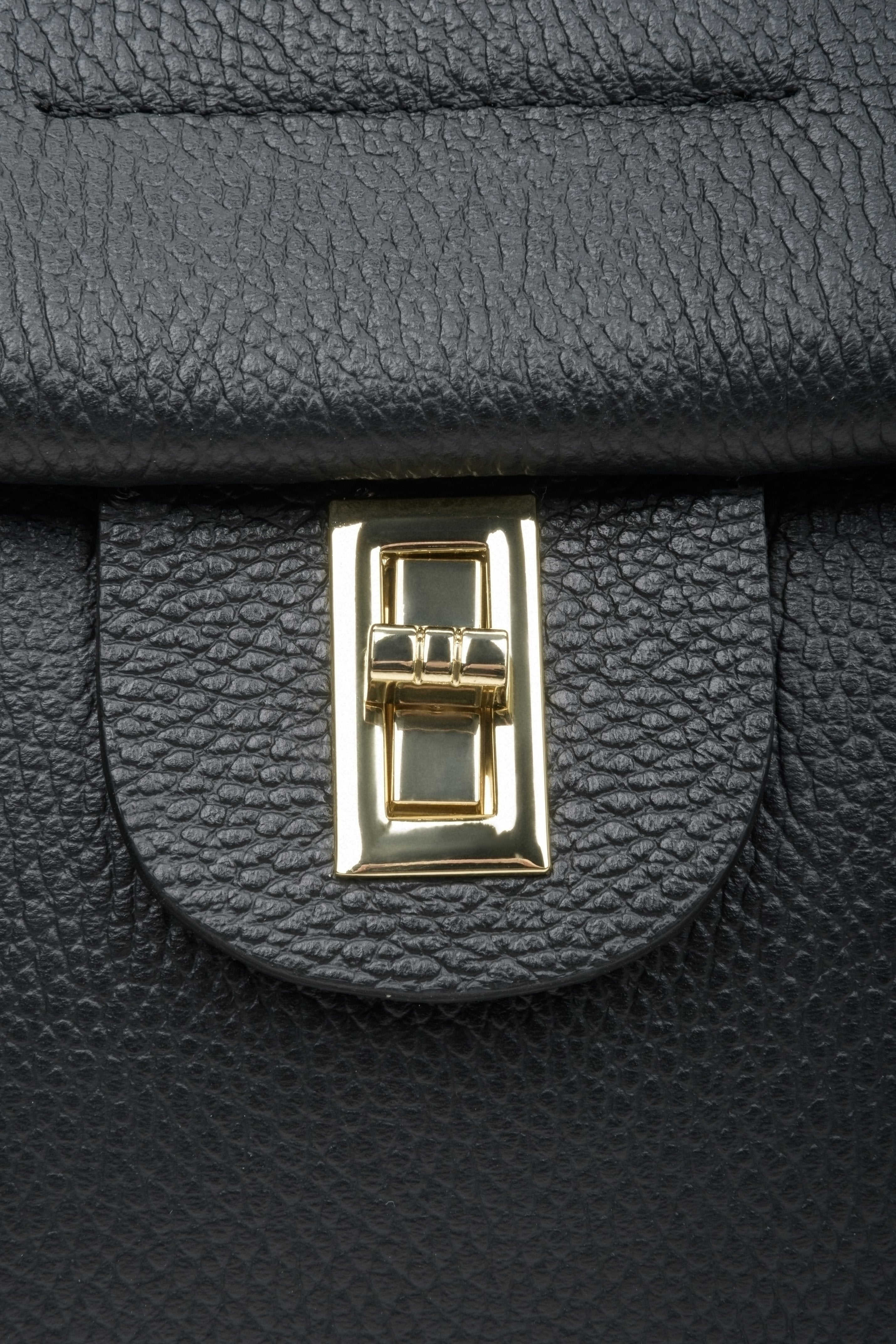 Women's black boxy-style handbag - close-up of the gold clasp.