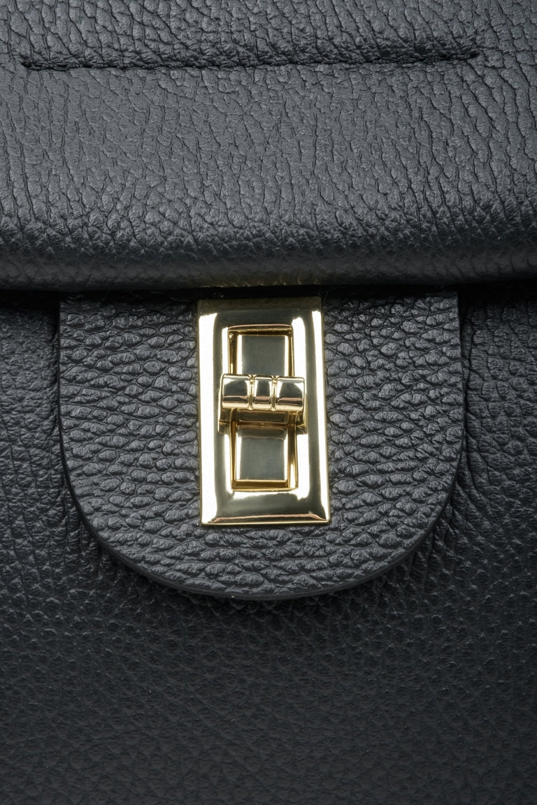 Women's black boxy-style handbag - close-up of the gold clasp.