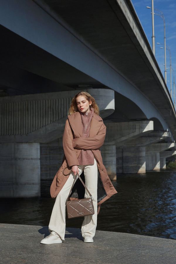 Estro's women's brown leather bag with quilting - the model in a fuller outfit.