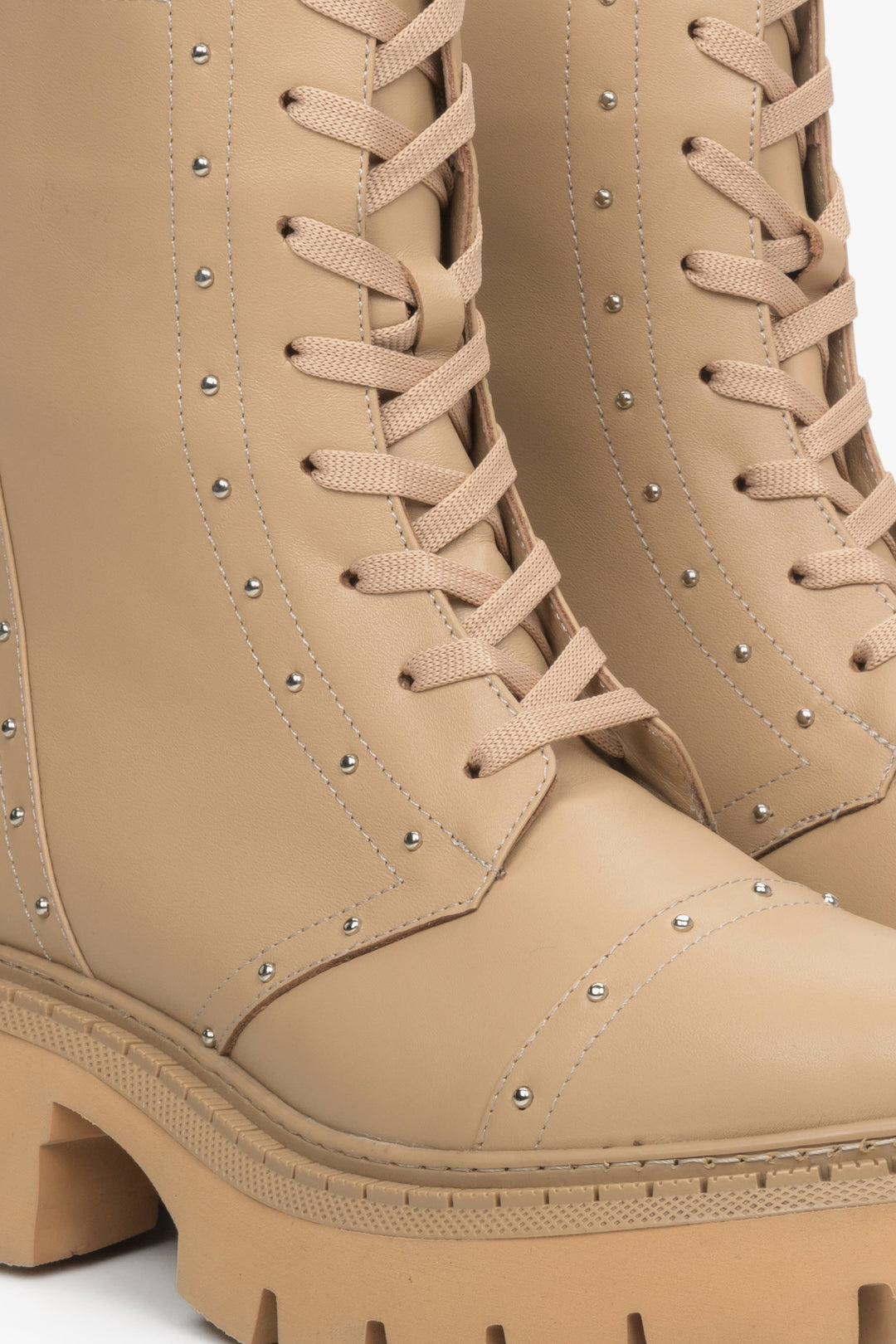 Beige leather ankle boots Estro - a close-up on decorative lacing and silver studs.