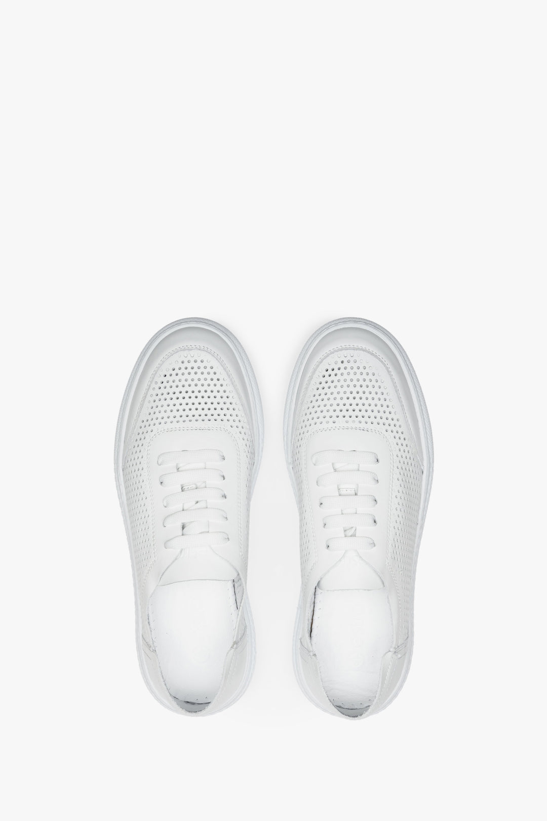 Perforated women's summer sneakers made of white genuine leather - presentation of the footwear from the top.