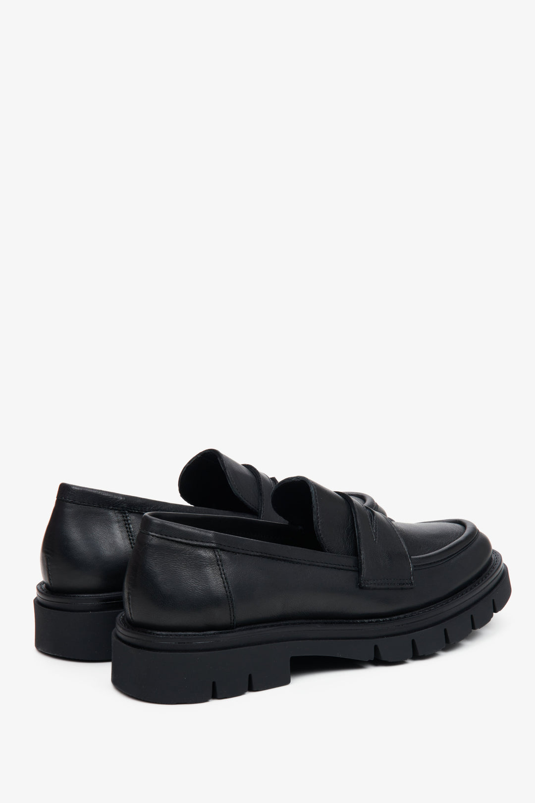 Women's black Estro loafers crafted of Italian leather - close-up on the buckle and side line of the shoes.