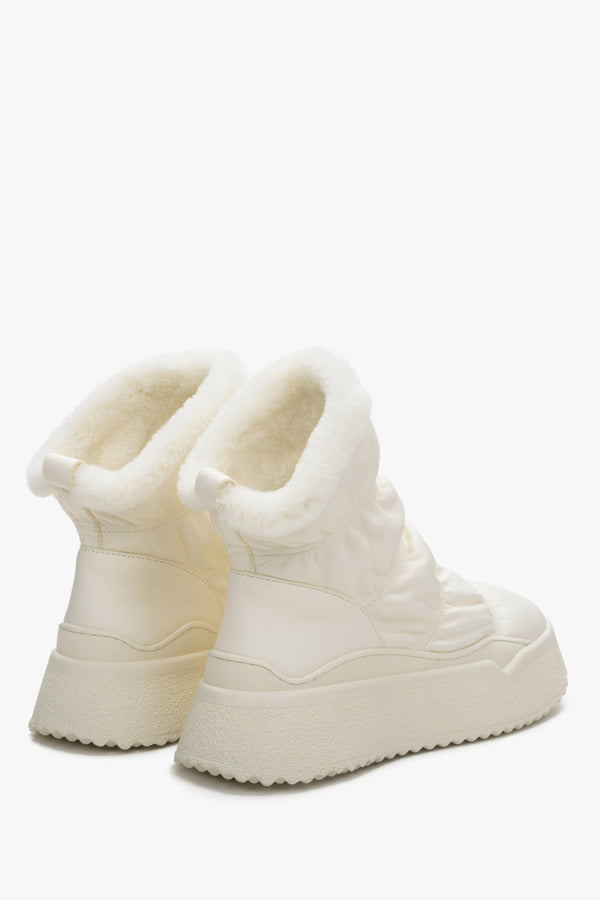 Women's light beige snow boots, fur lined - close-up on shoe sideline.