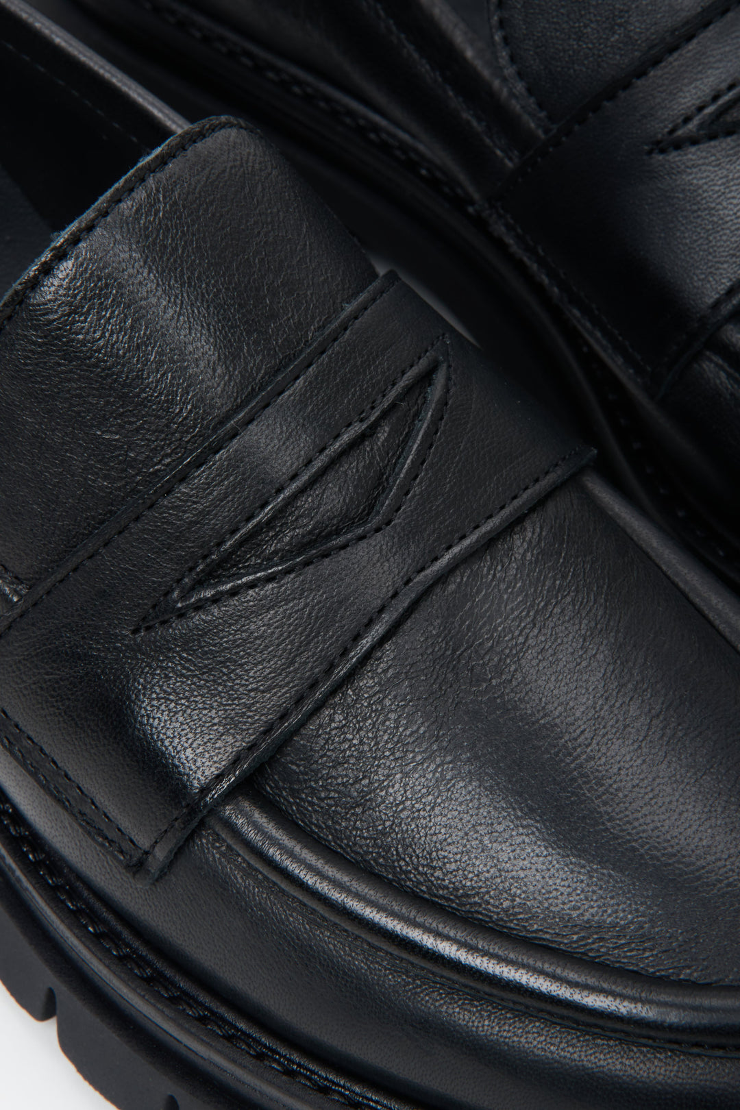 Women's slip-on penny loafers in black - close-up on the details.