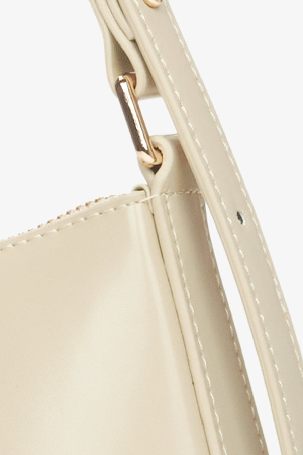 Women's beige baguette bag -  a close-up on details.