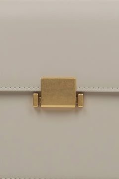 Women's milky-beige handbag - close-up of the snap closure.