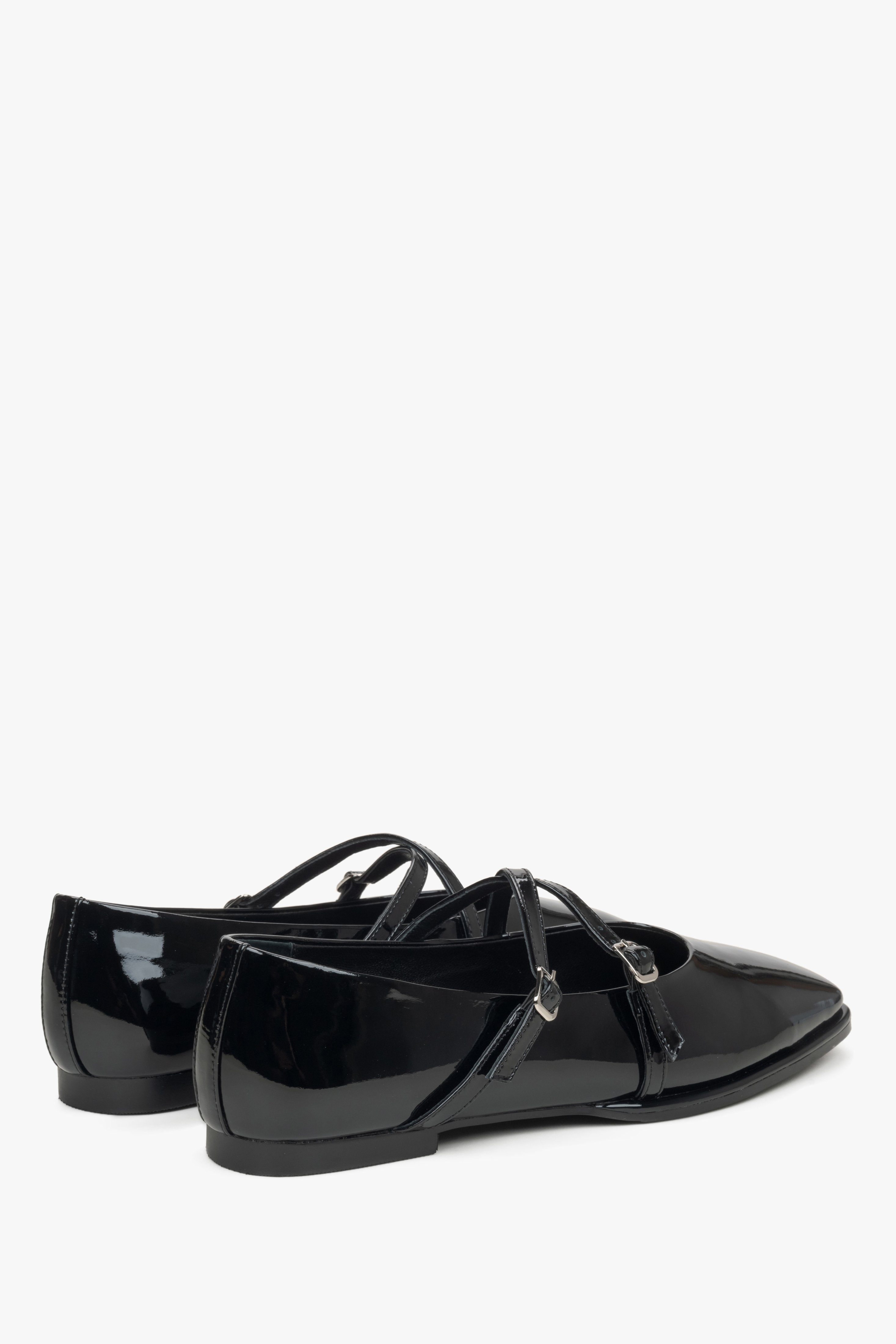 Women's black patent leather ballet flats with a buckle.