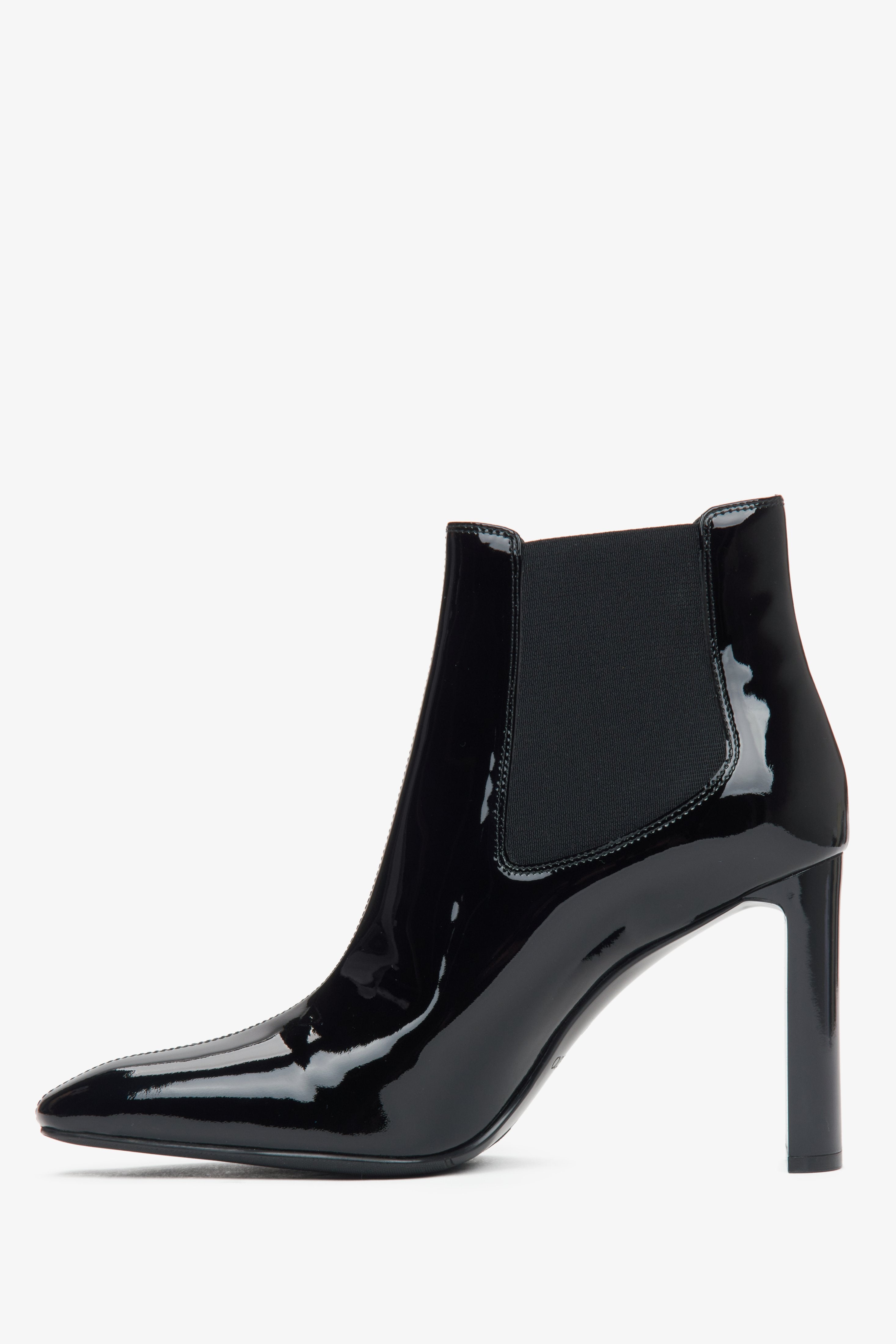 Stylish black ankle boots made of patent genuine leather with a high block heel from Estro - side profile of the shoe.