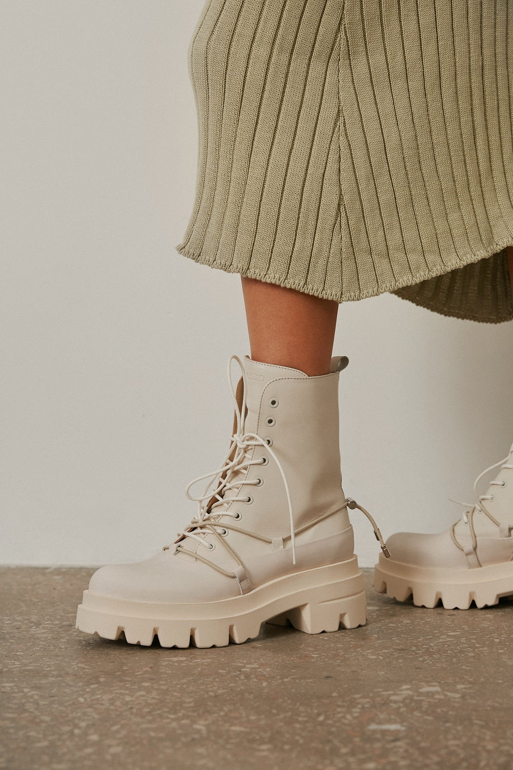 Women's beige leather ankle boots for fall - footwear presentation on a model.