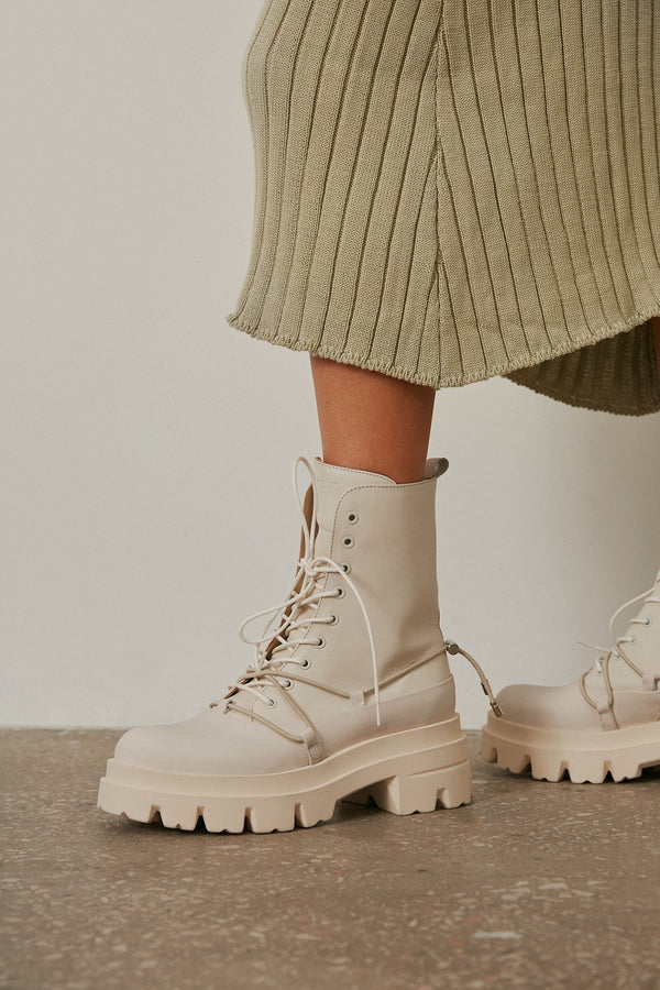 Women's beige leather ankle boots for fall - footwear presentation on a model.