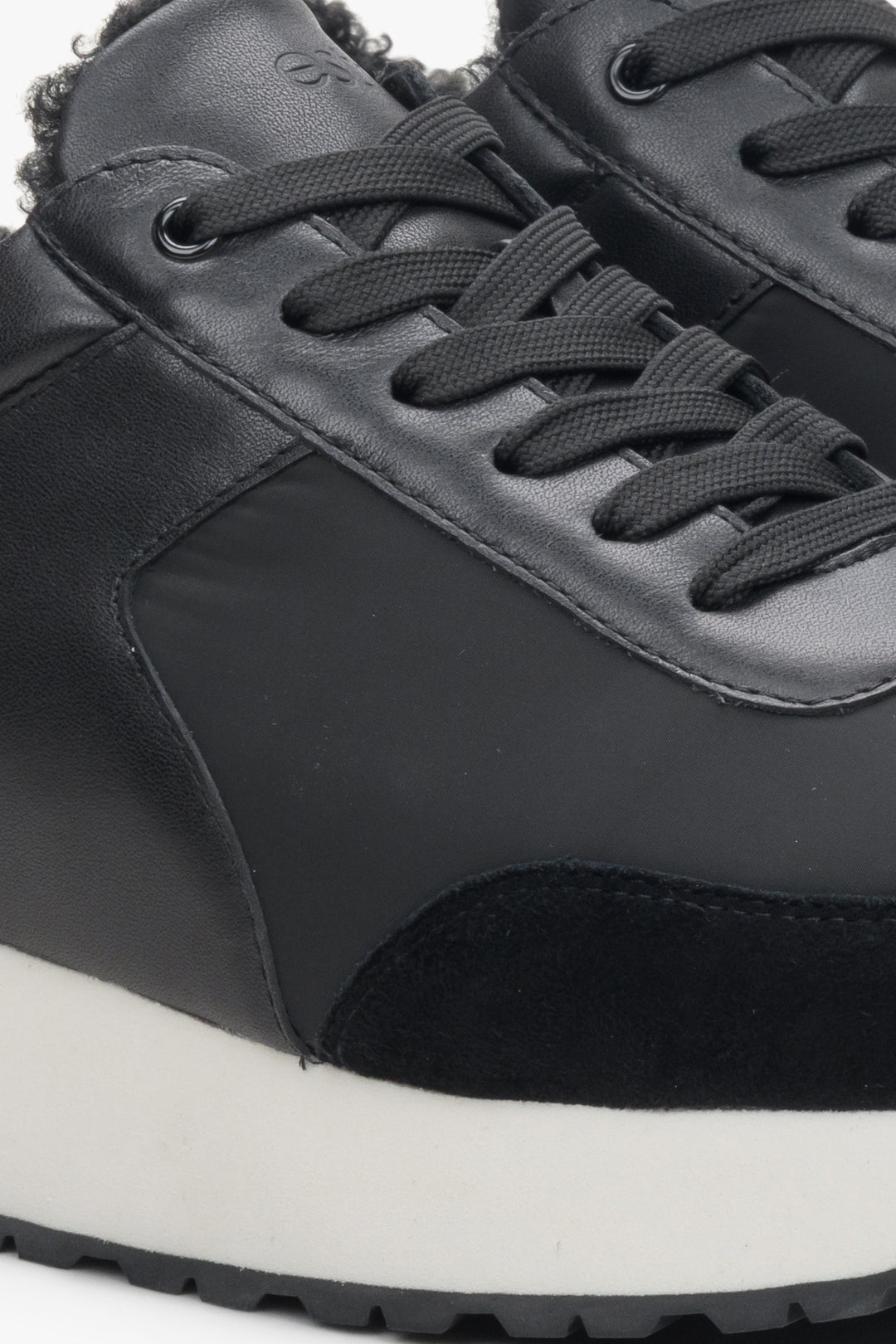 Women's winter sneakers with insulation in black made of leather and velvet - close-up on the details.