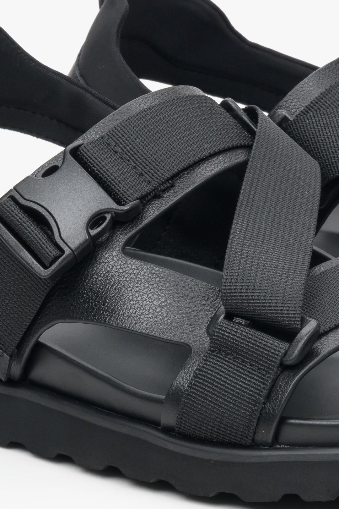 Comfortable men's summer sandals in black, made from genuine leather and textiles - close-up on the details.