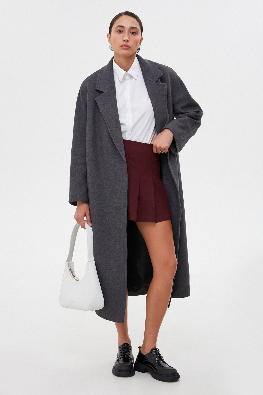 Long grey bucket coat tied at the waist.