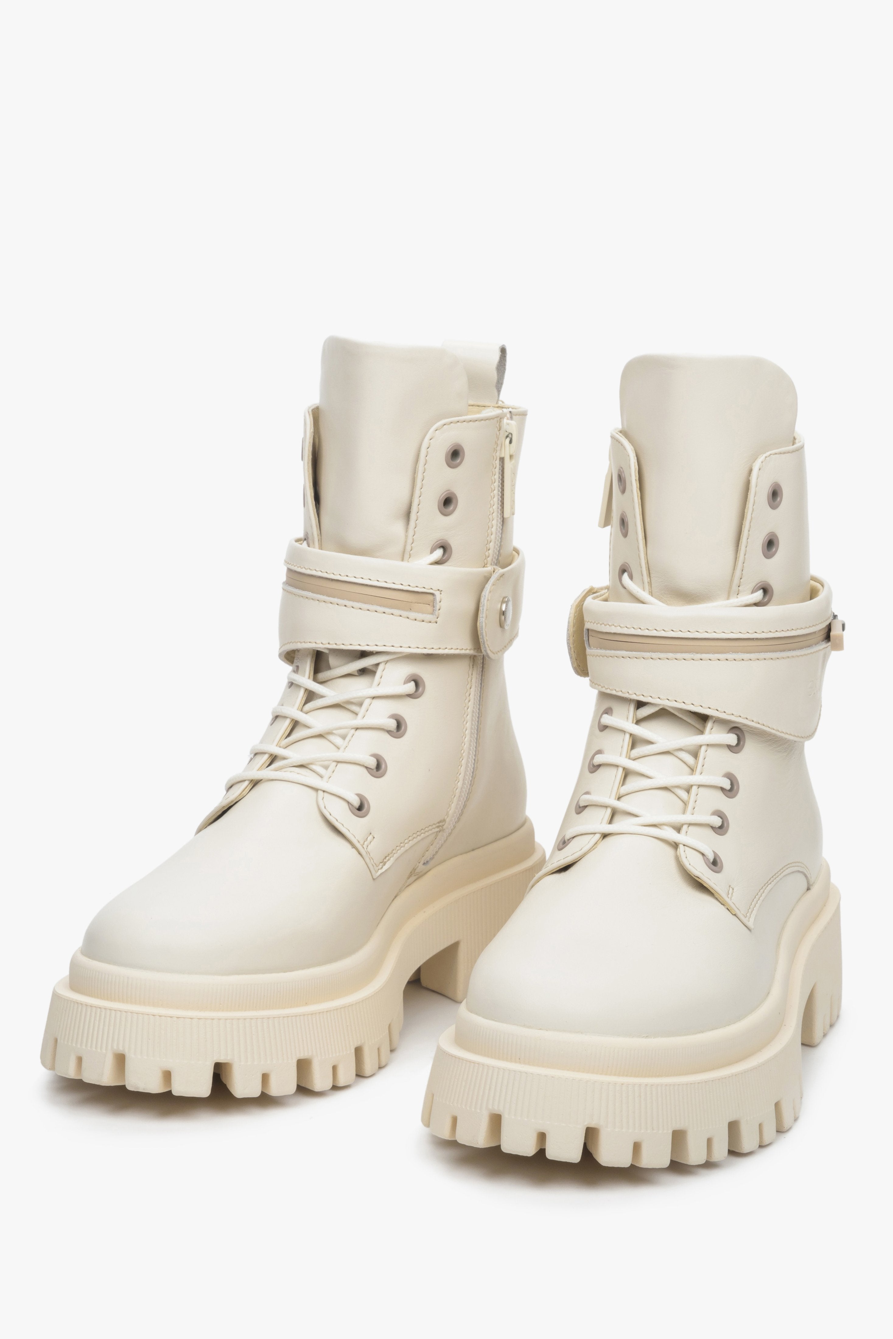 Estro high women's boots made of light beige genuine leather with lacing, zipper and decorative belt - close-up of the front of the shoes.