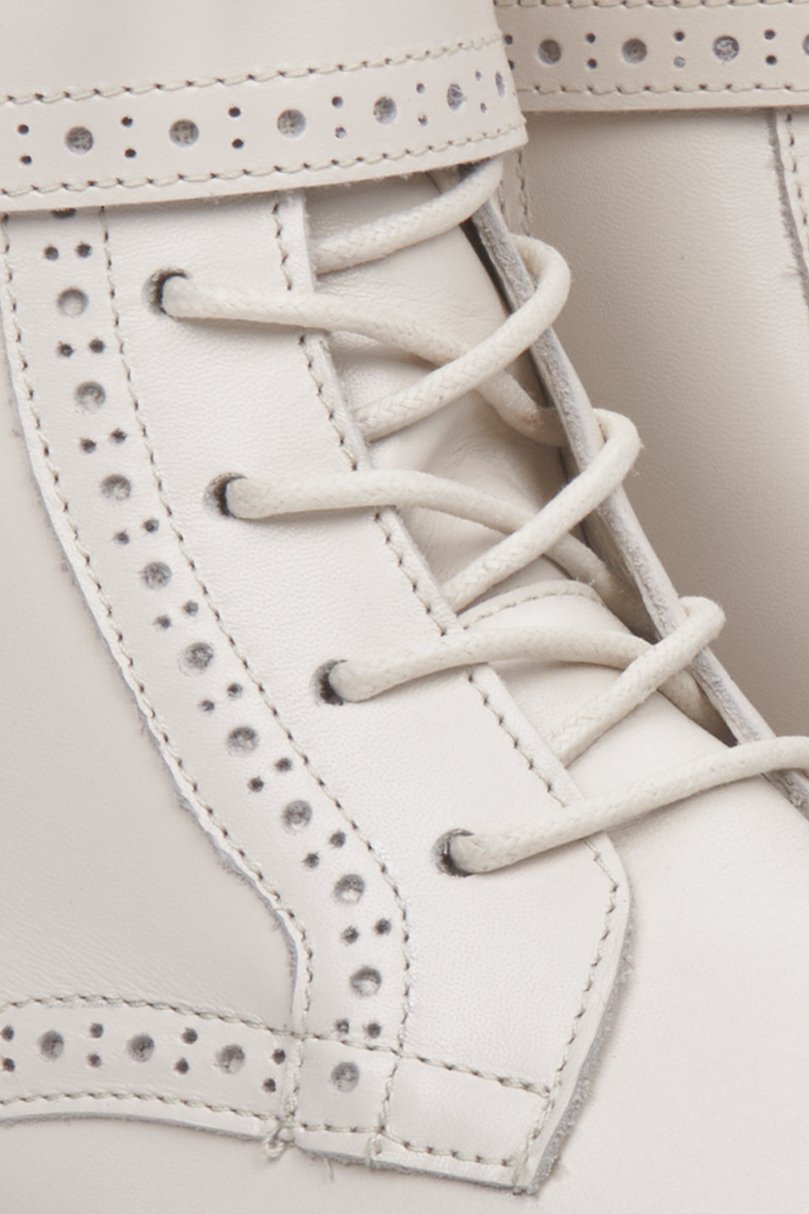 Women's light beige ankle boots - close-up on a decorative lacing.