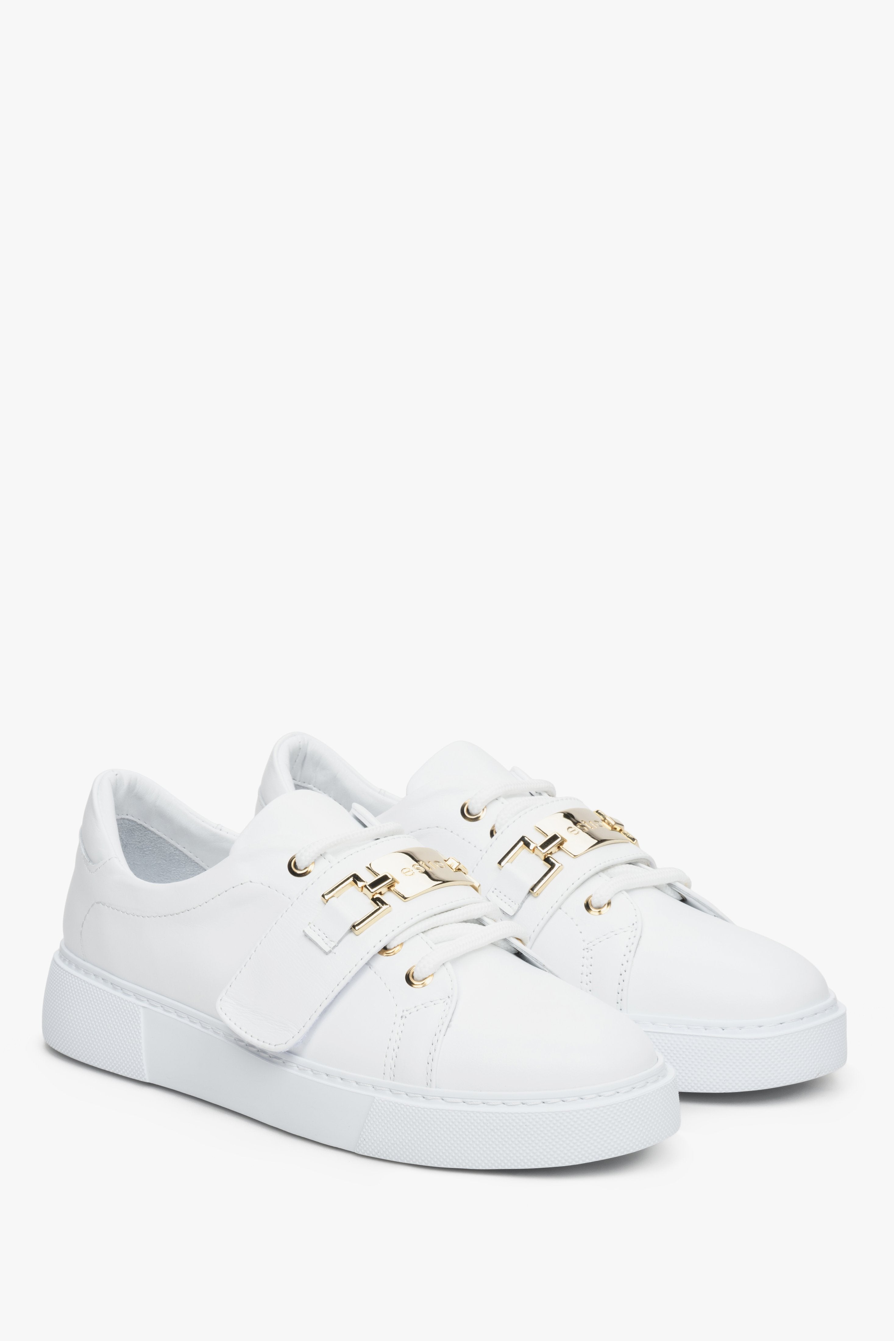 Women's white leather sneakers by Estro with a gold embellishment.