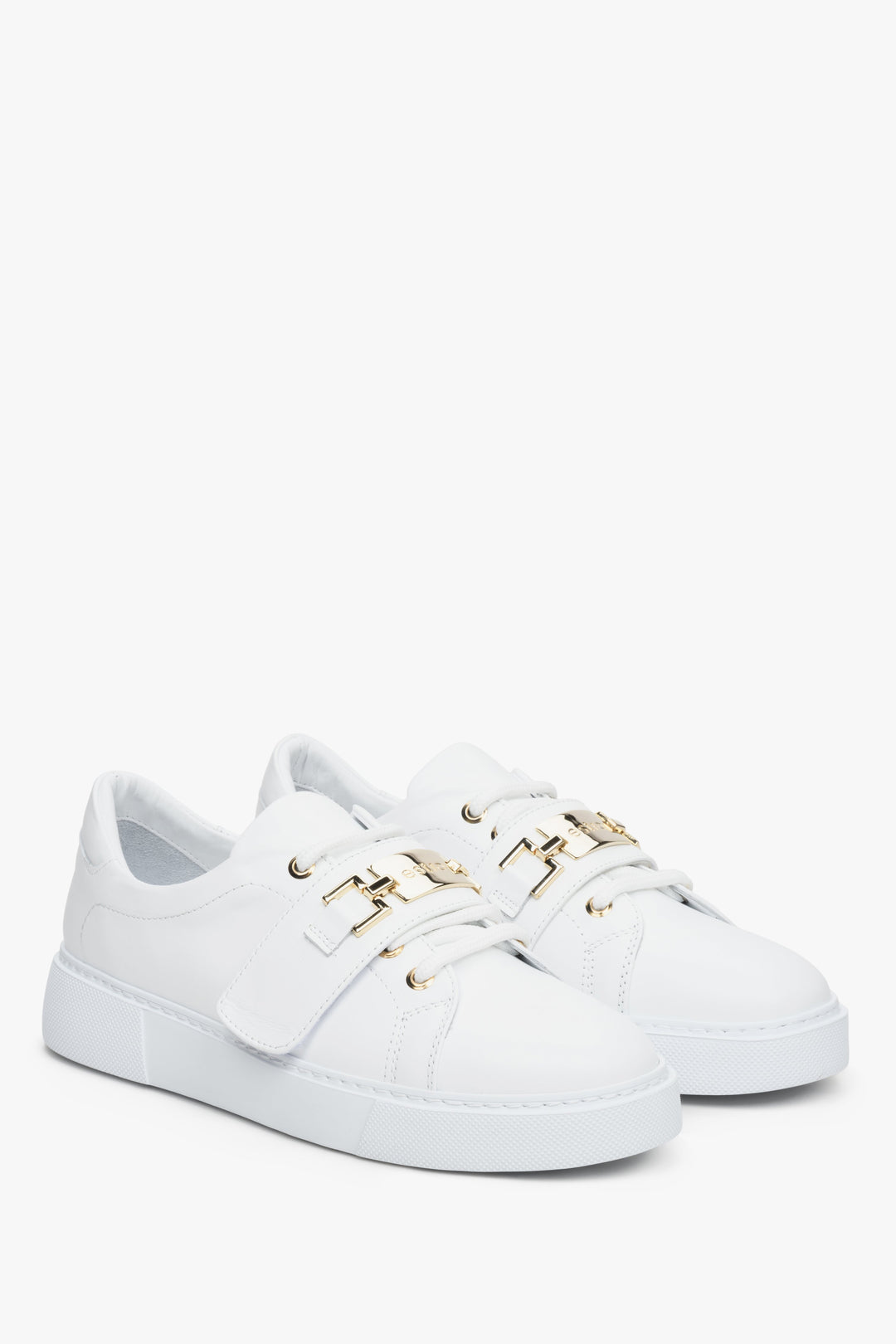 Women's white leather sneakers by Estro with a gold embellishment.