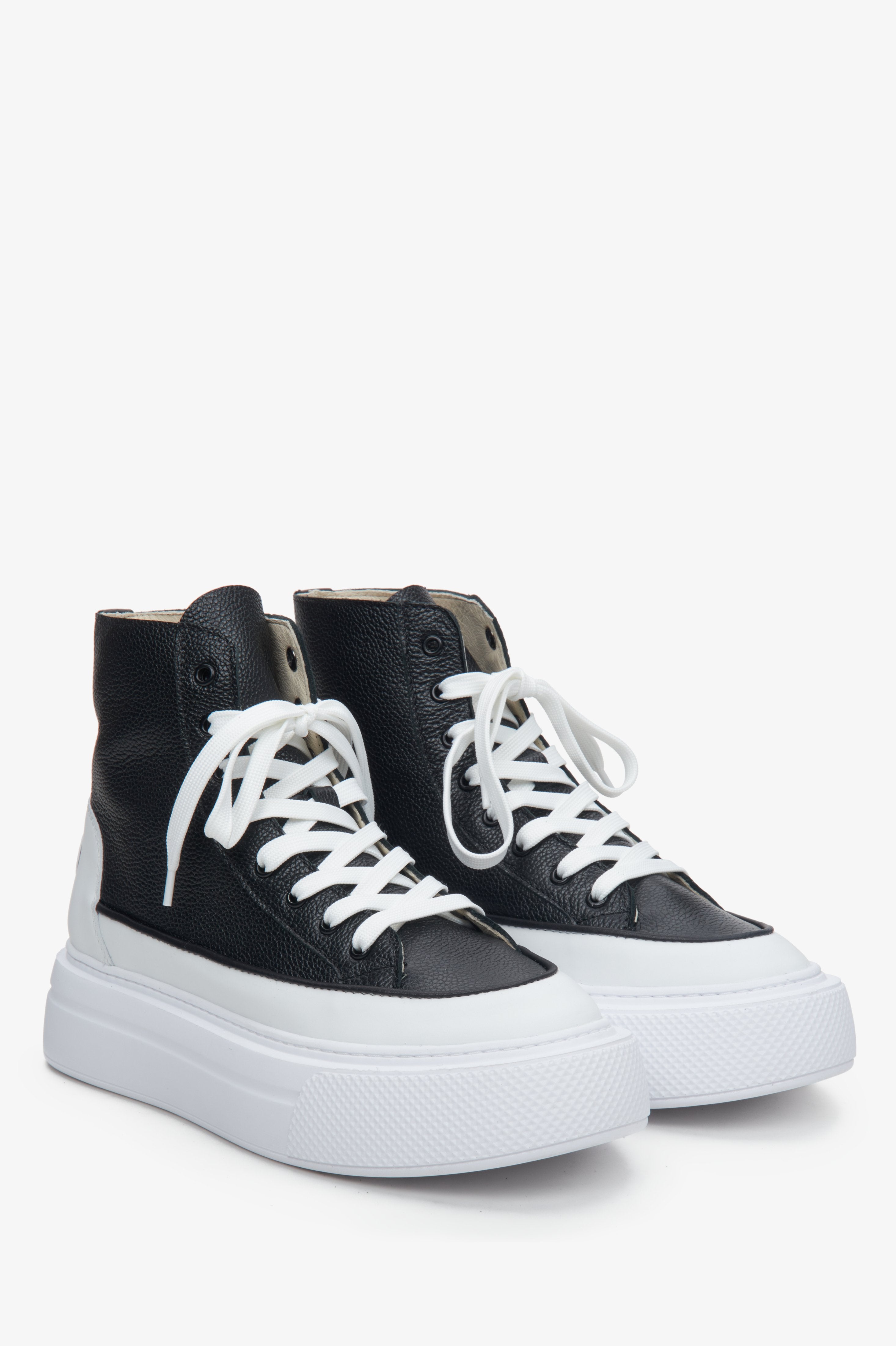 White and black high-top leather women's sneakers - close-up of the lacing system.