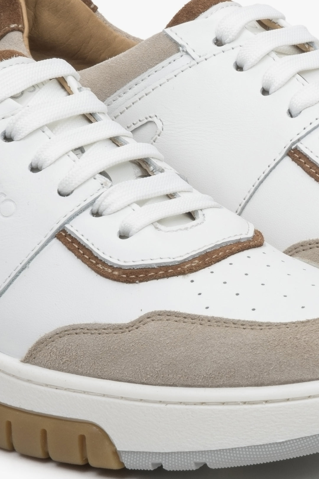 Women's sneakers made of genuine leather and suede in beige and white - close-up on the details.