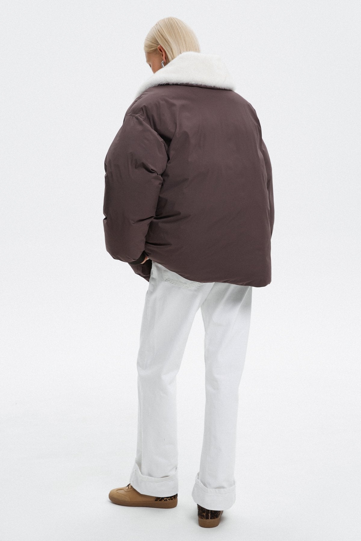 Dark brown women's bomber jacket by Estro – back view of the model.