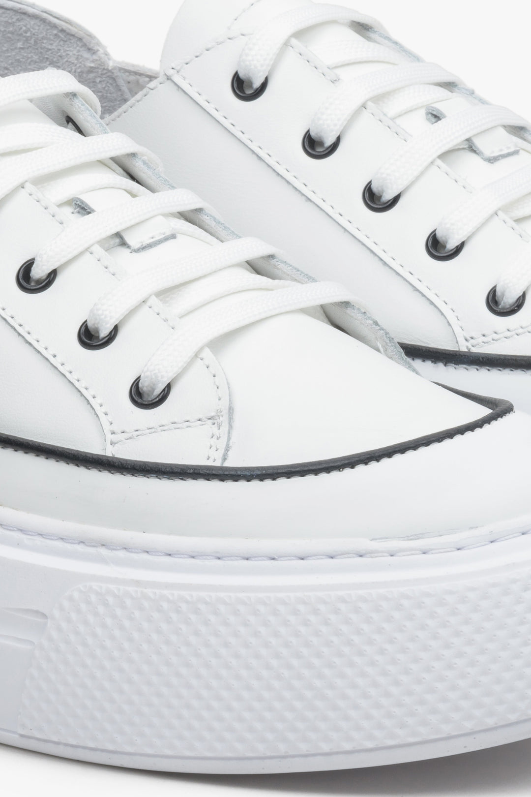 Women's low top sneakers made of genuine leather in white - close-up on details.