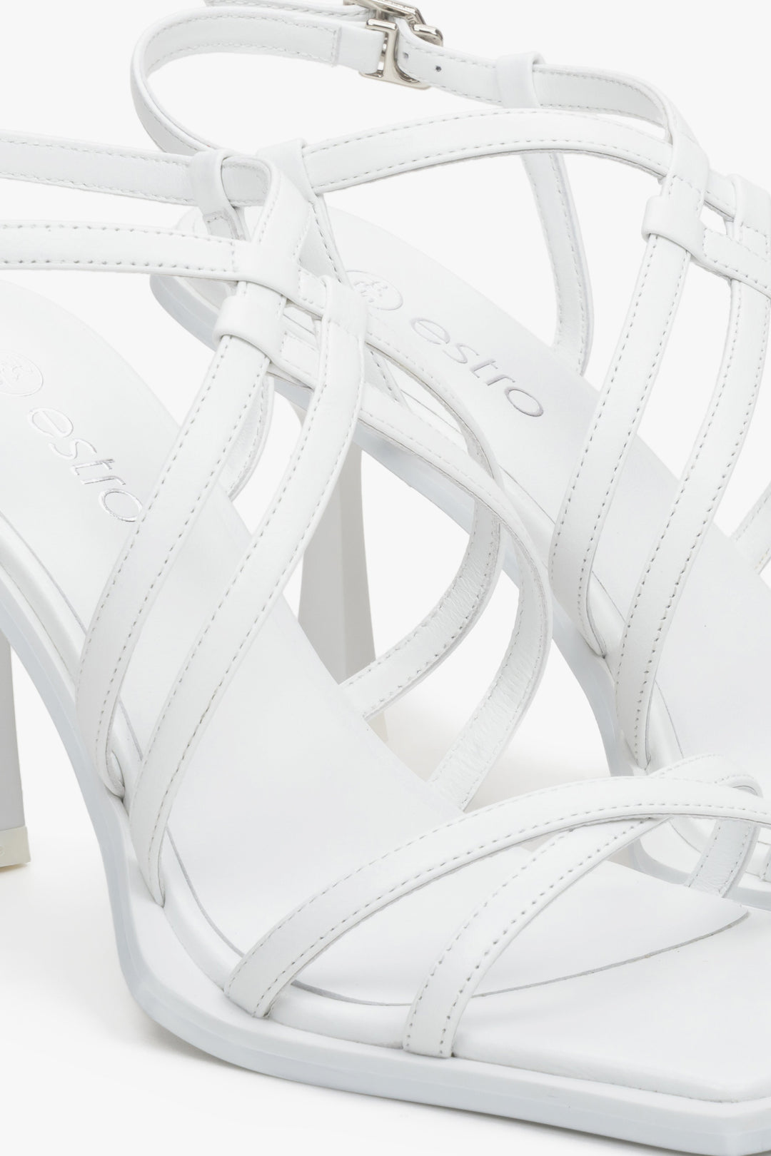 Women's strappy white sandals with a funnel heel - close-up on details.