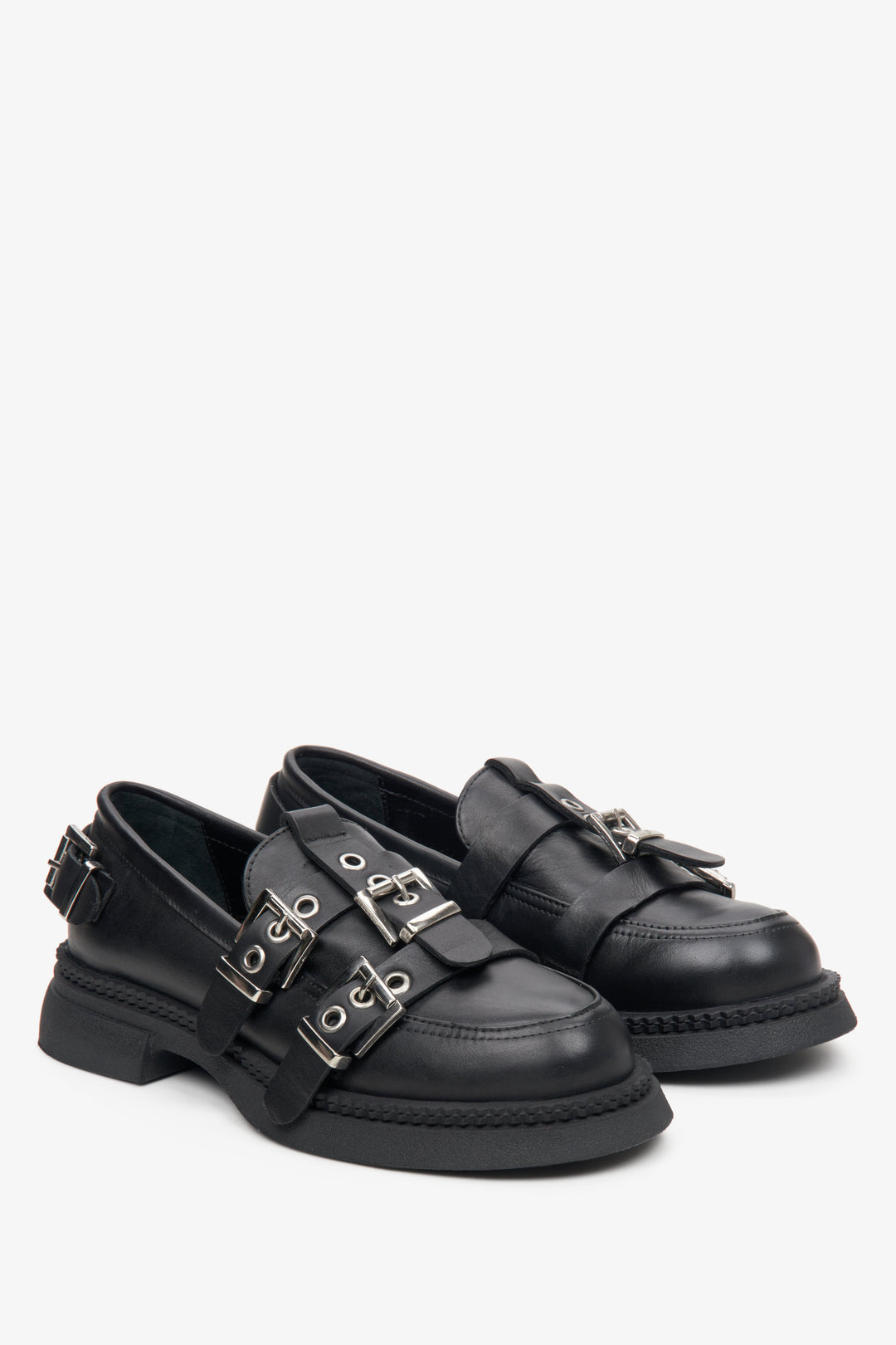 Women's black leather loafers with silver buckles.