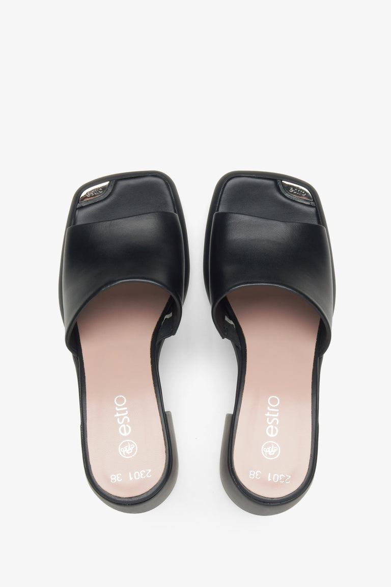 Women's mules in black color with block heels - presentation of footwear from above.