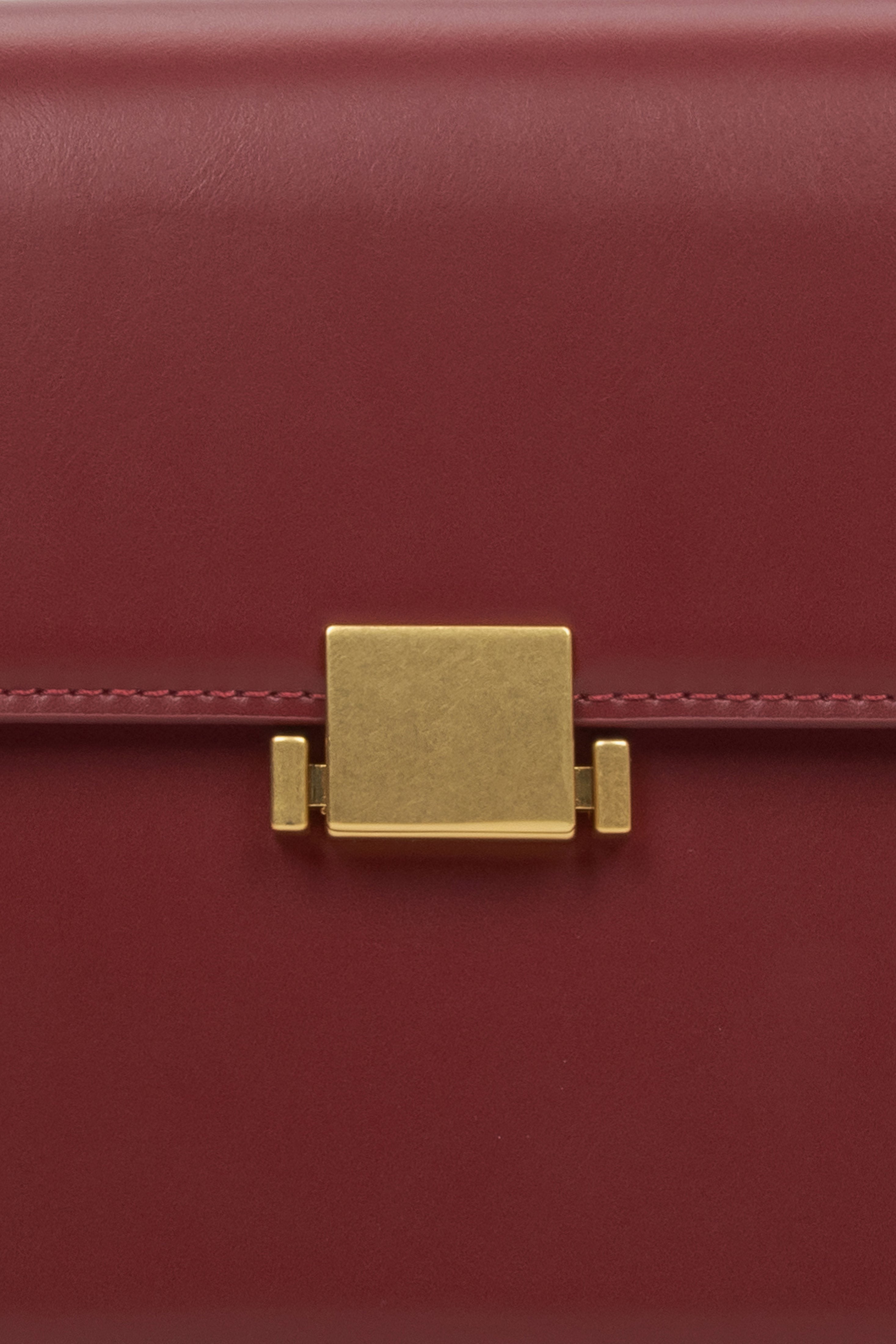 Women's burgundy handbag - close-up of the snap closure.