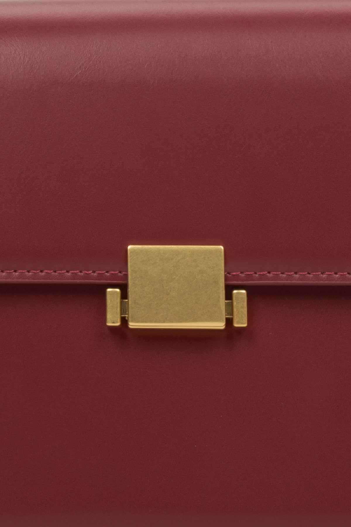 Women's burgundy handbag - close-up of the snap closure.