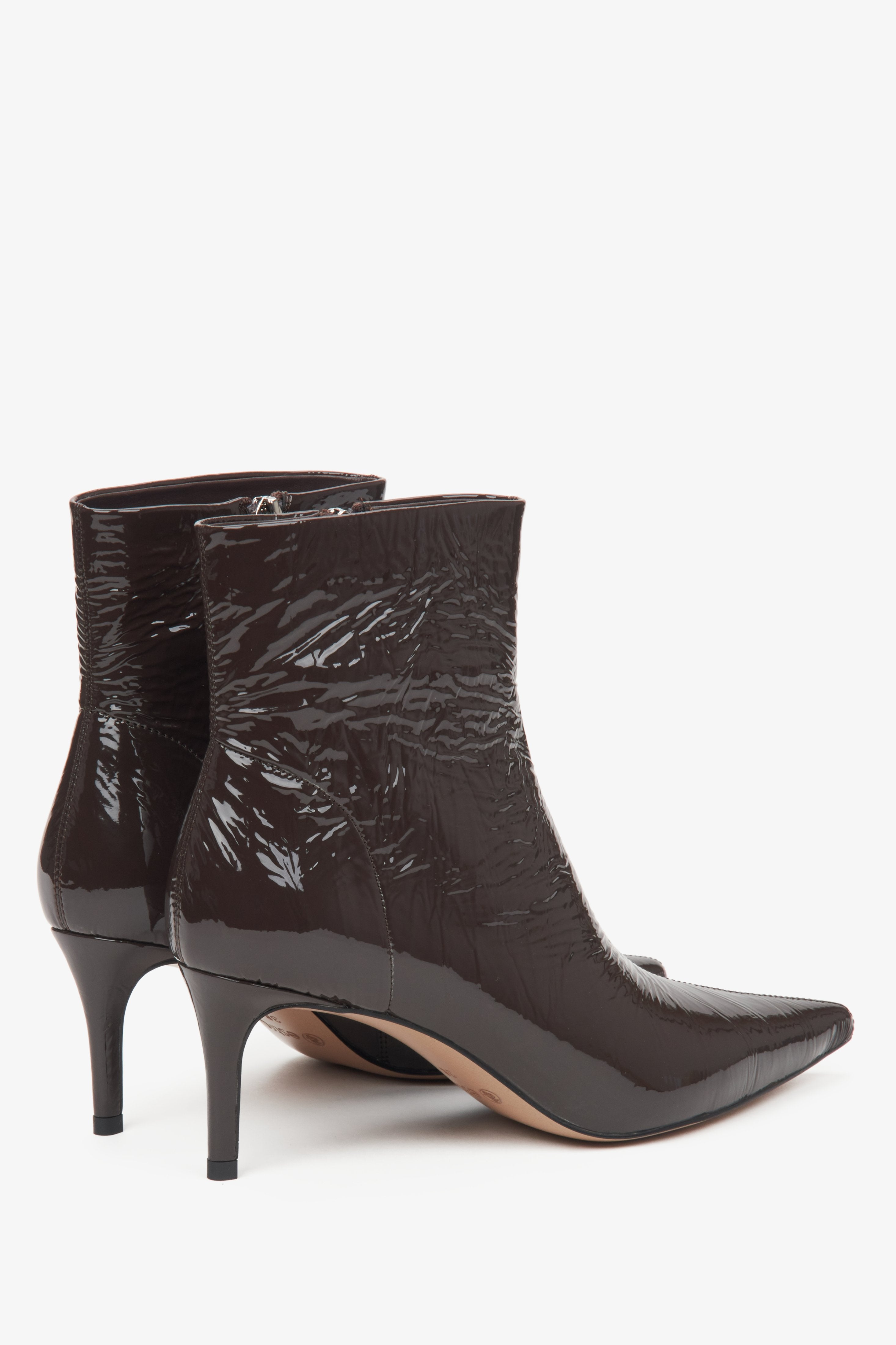 Dark brown women's ankle boots by Estro made of patent natural leather – close-up of the heel and side line of the shoe.