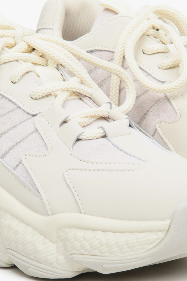 Light beige women's sneakers with suede and textile on a chunky sole - close-up on the details.