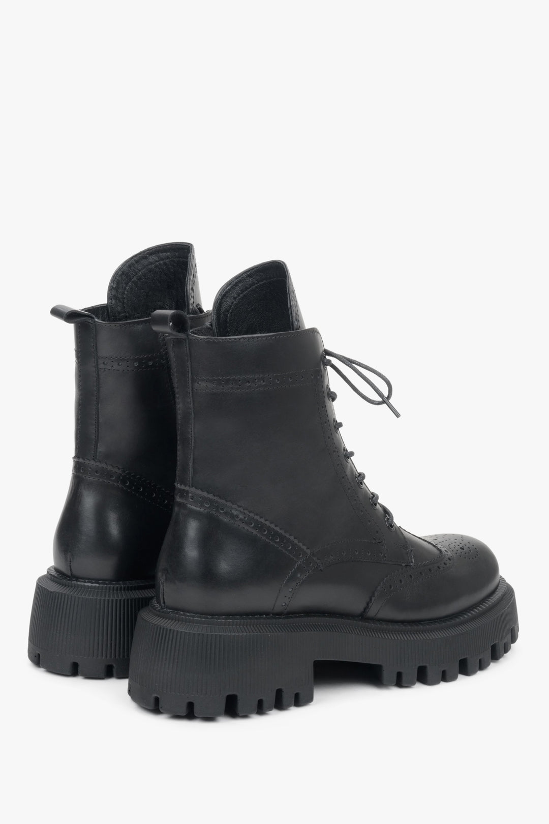 Women's black leather ankle boots with decorative lacing - close-up of the side and heel lines of the boots.