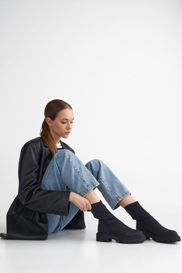 Black women's slip-on ankle boots with a flexible upper - presentation on a model.