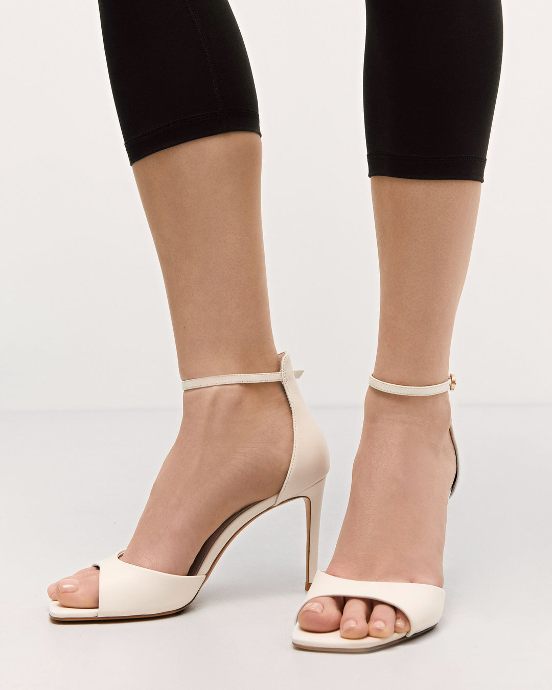 Stylish white women’s sandals by Estro, made from high-quality genuine leather, featuring an elegant high heel – shown on foot.
