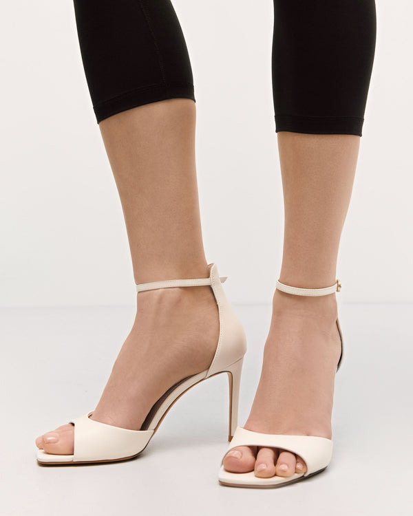 Stylish white women’s sandals by Estro, made from high-quality genuine leather, featuring an elegant high heel – shown on foot.
