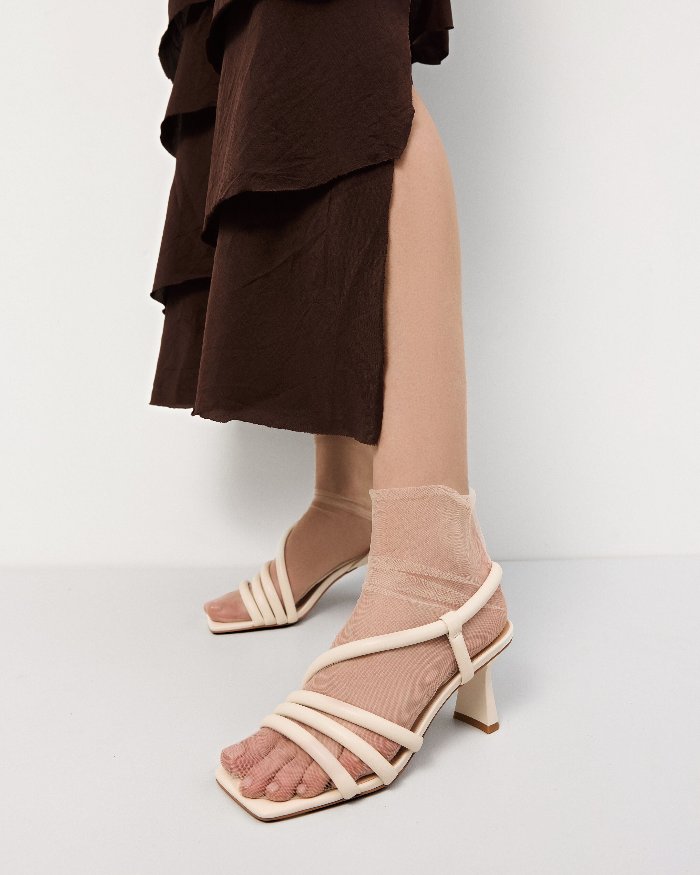 Women's sandals by Estro in light beige with thin straps and a heel – shown on foot.