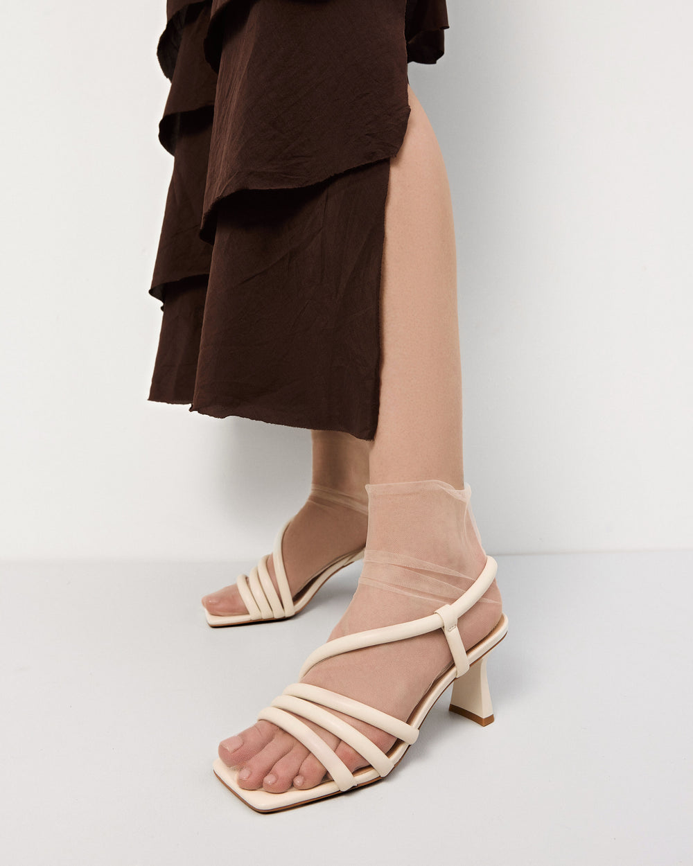Women's sandals by Estro in light beige with thin straps and a heel – shown on foot.