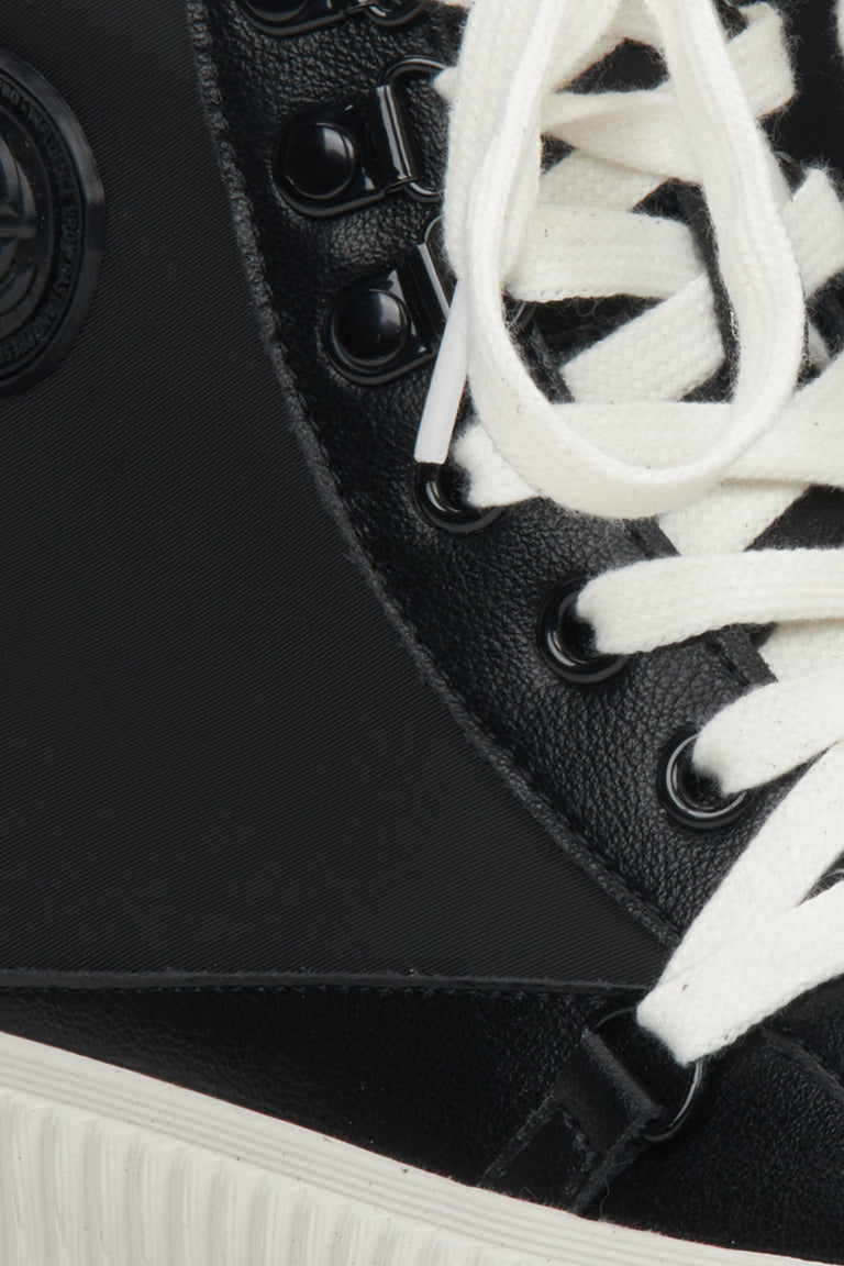 Women's black leather sneakers by Estro - close-up on details.